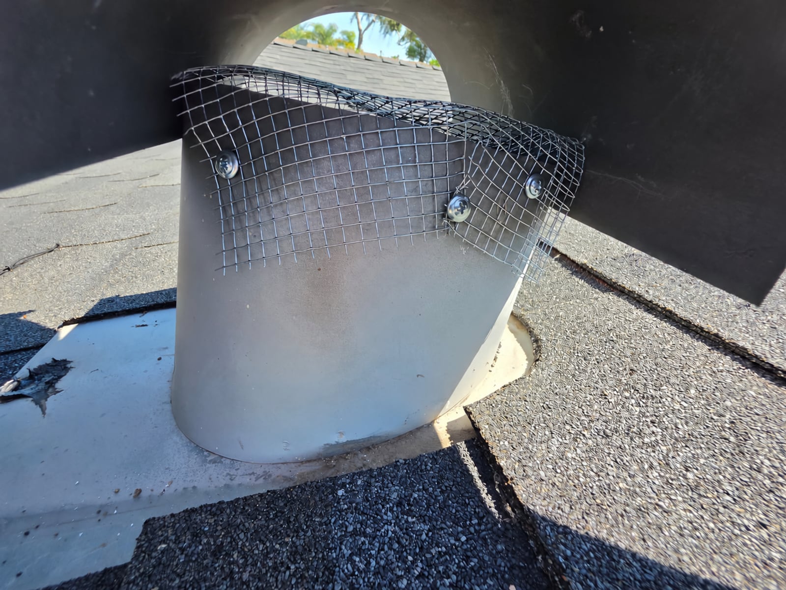 Metal screening installed around a rooftop vent during rodent exclusion work at a La Habra property