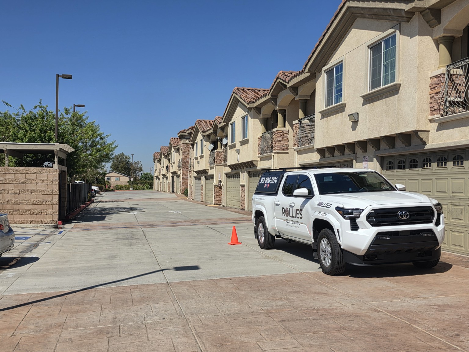 Rollies Pest Control service truck at a multifamily property in the Inland Empire